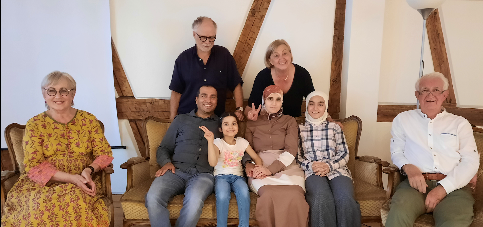 Familie Shttewy mit Ayman, Ghufran, Rim und Rhagad, im Hintergrund Martina Schneider und Kassenwart Dr. Helmut Schneider, links Vorsitzende Dr. Hildegard Müller-Erhard, rechts stellvertretender Vorsitzender Dr. Faidi Mahmoud. Nicht im Bild: Fotograf Michael Erhard Rhagad mit Schultüte am Einschulungstag
